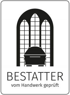 Das Markenzeichen der Bestatter ist ein Sarg vor einem Kirchenfenster.